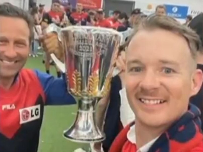 Mr Burbank, pictured left, and Mr Babbage, right, with the AFL premiership trophy on Saturday night. Picture: Channel 7