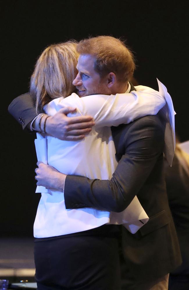 A woman hugs Prince Harry at the summit. Picture: AP