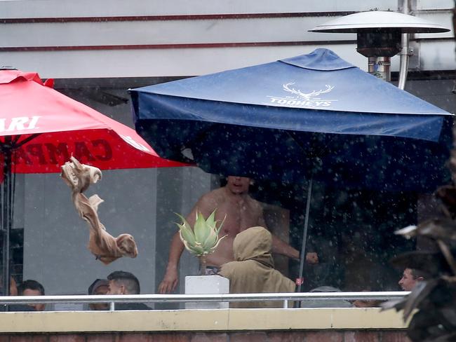 Bulldogs players arrive at the Harbour View Hotel in The Rocks for Mad Monday. A player rips off his shirt and throws it over the balcony. Picture: Toby Zerna