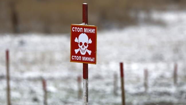 A sign warning of mines is displayed as deminers working for the HALO Trust clear mines from former Russian frontline positions. Picture: Getty Images