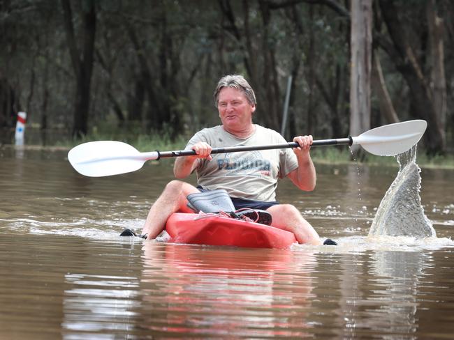 An Echuca resident paddles through a flooded street. Picture: David Caird