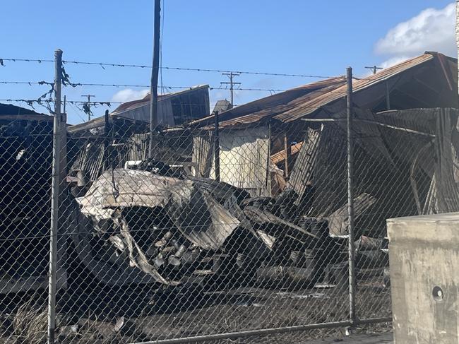 Police are standing guard after a large fire destroyed an industrial shed in West Mackay. Picture: Zoe Devenport