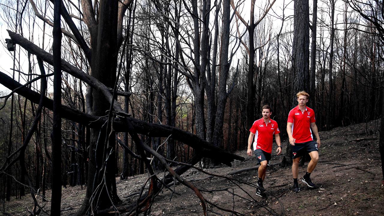 Callum Mills (right) and his teammate Jake Lloyd survey the bushfire damage Picture: Phil Hillyard