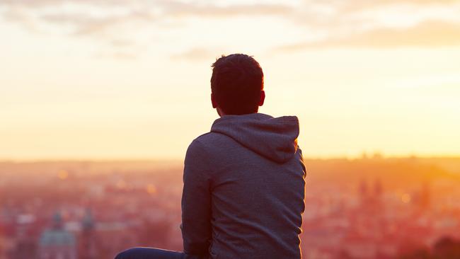 Young man is looking at the sunrise