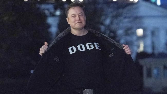Elon Musk flashes his T-shirt that reads 