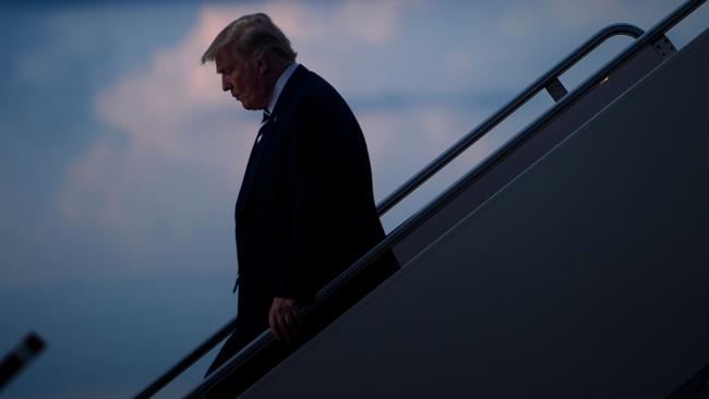 Mr Trump strikes a lonely figure as he disembarks from Air Force One. Picture: Brendan Smialowski/AFP