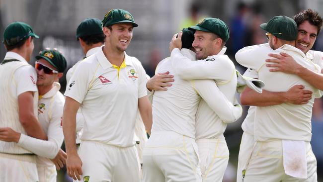 Australian players celebrate after Pat Cummins (right) secured the final wicket to deliver Ashes victory.