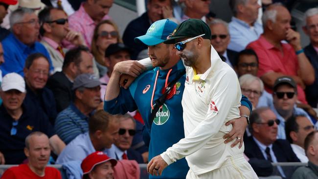 Australia's Nathan Lyon is helped off the field after picking up an injury. Picture: AFP