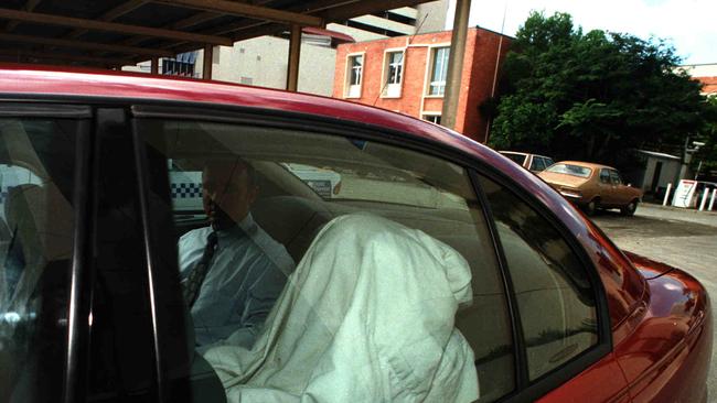 July 1998: Kevin Baggott hides under a blanket as he is taken from Southport Court.