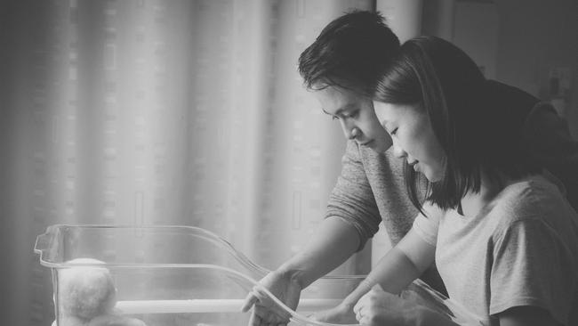 Adrian and Lina Wong look down at their stillborn son, Mason, born in January 2016. Picture: Adrienne Myszka.