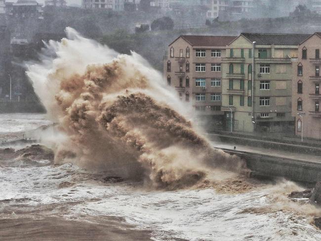 Waves hit a sea wall in front of buildings in Taizhou, China's eastern Zhejiang province. Picture: AFP