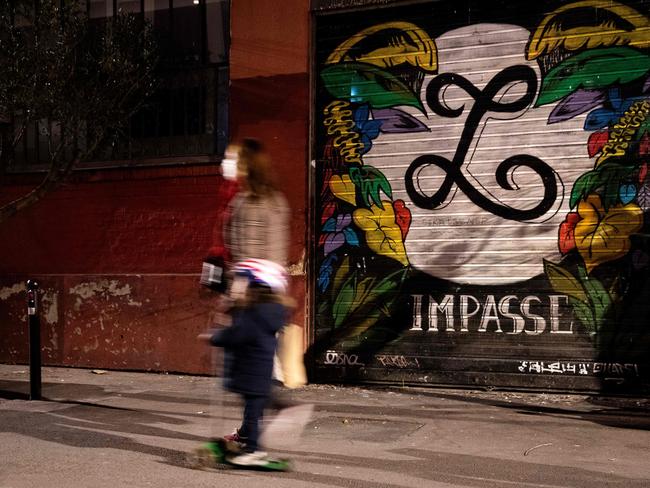 A woman walks past a closed restaurant in Paris. Picture: AFP