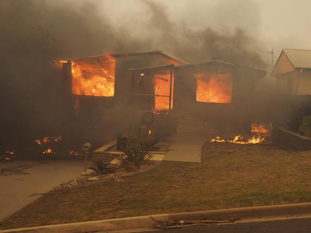 A bush fire rages in the town of Tathra on Sunday afternoon, March 18, 2018. Picture: John Ford