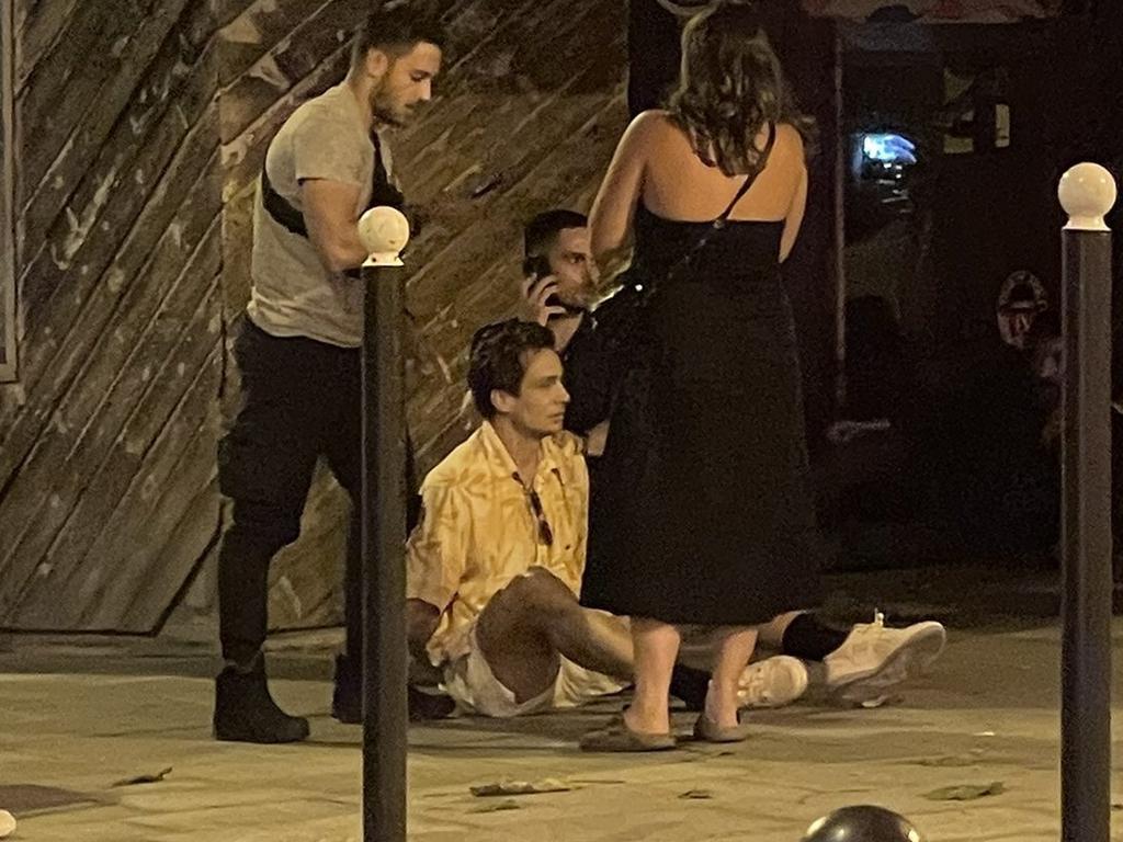 Australian hockey player Tom Craig sits on the footpath in Paris after being arrested.