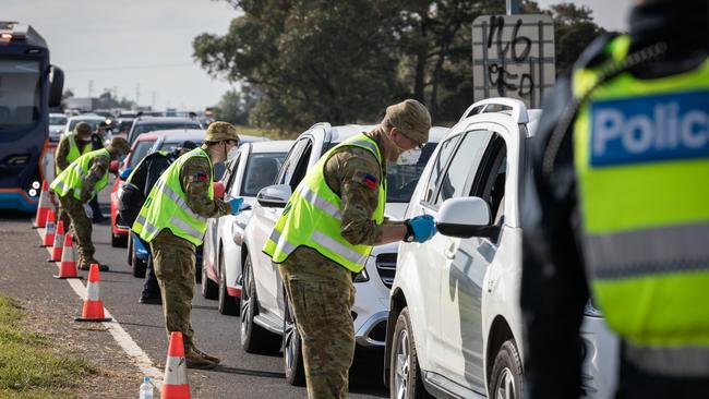 Australian Army Reservists work with Victorian Police Officers at the Little River Police vehicle checkpoint in Victoria