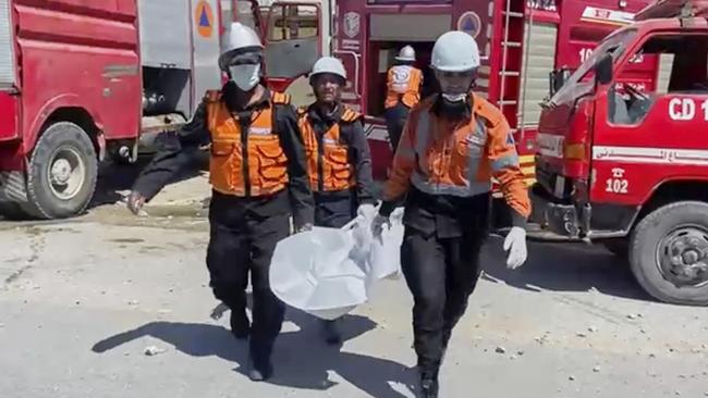 Workers collect human remains after an Israeli strike in Khan Younis killed nine of married doctors’ 10 children. Picture: Gaza Civil Defense via AP