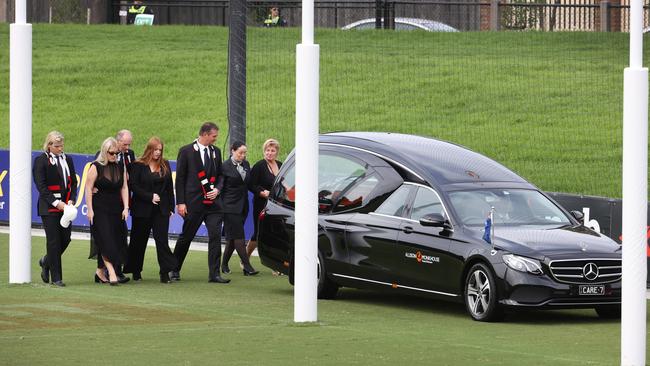 Family and friends follow the Hearse caring Shane Warne coffin for a lap of the ground. Picture: David Caird