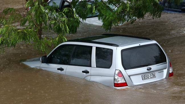 Cars submerged at the rear of the Robina Hospital. Picture: NIGEL HALLETT