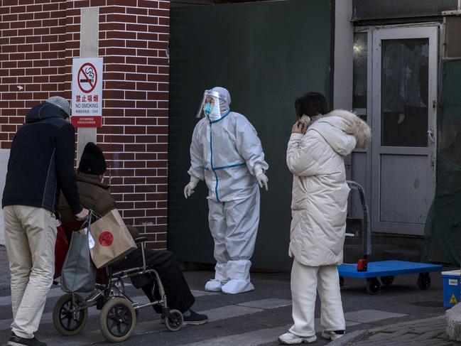 A medical worker wears PPE as she assists a patient at a fever clinic treating Covid patients on December 21, 2022 in Beijing, China. Picture: Kevin Frayer/Getty Images