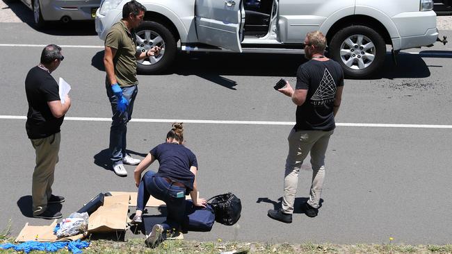 Police collect evidence at the scene of the sting in Centennial Park. Picture: John Feder