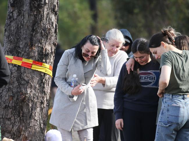 They huddled close in grief. Picture: John Feder/The Australian