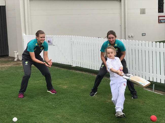 Matisse Easton, 8, unleashes at Allan Border Field at Jess Jonassen(left) and Beth Mooney look on as they prepare to tackle England onSunday.