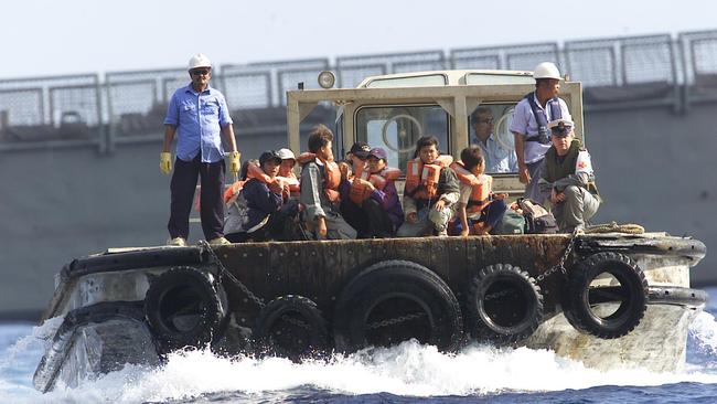 Vietnamese asylum seekers are transported to the Christmas Island detention centre from HMAS Canberra in 2003. Picture: Andy Tyndall