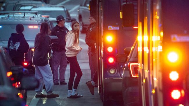 Students are escorted from a church next to the Abundant Life Christian School and loaded on buses. Picture: Getty Images