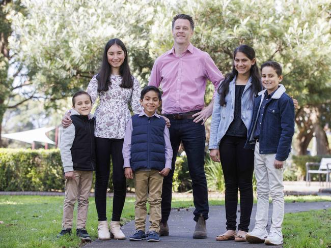 Chris Minns – pictured with kids from the Elachi family (left) John, 5, Aalia, 13, Joseph, 7, Amira, 11, and James, 9 – has pledged $60 million to non-government school preschools. Picture: David Swift