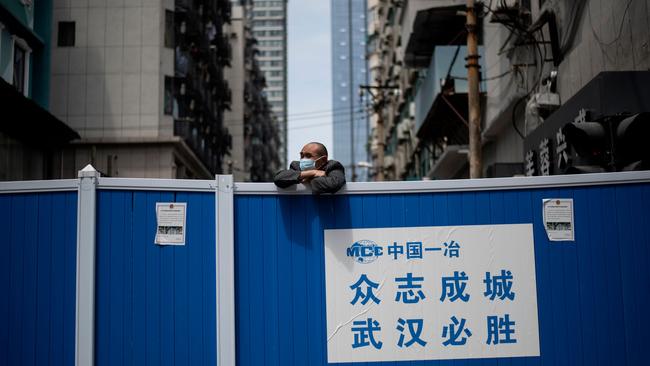 A man looks over a barricade set up to keep people out of a residential compound in Wuhan, China. Picture: AFP