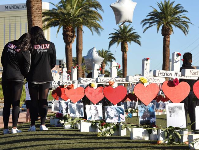 Members of the University of Las Vegas prom squad visit 58 white crosses for the victims of the shooting. Picture: Robyn Beck/AFP