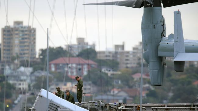 Crew on their phones on-board the USS Wasp as it is docked at Garden Island in Sydney. Picture: Jonathan Ng