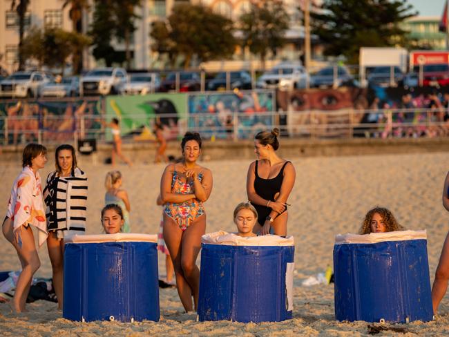 People sit in ice baths during a cryotherapy class at Bondi Beach early in the morning. Picture: Alexi Rosenfeld/Getty Images.