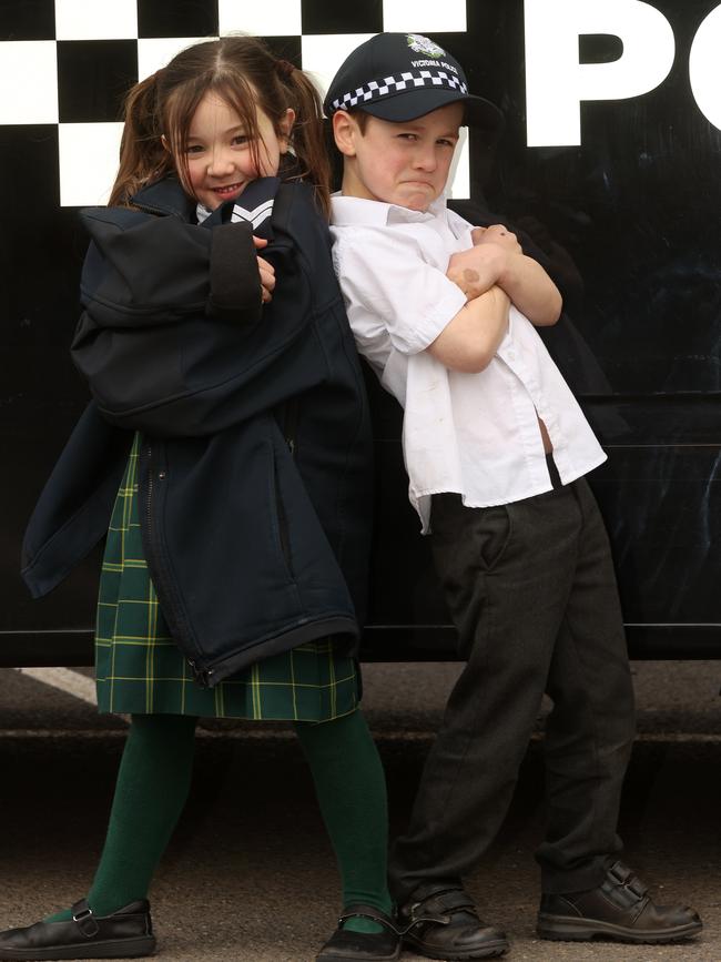 Covenant College foundation students Tilly, 6, and Finn, 5, try on police uniforms and attitude as part of a Victoria Police school visit. Picture: Alison Wynd
