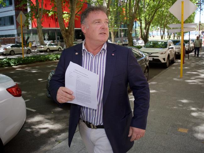 Senator Rod Culleton holds court papers outside the Federal Court in Perth. Picture: AAP