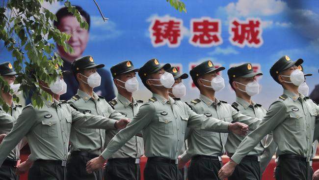 Chinese People's Liberation Army (PLA) soldiers march past a banner depicting Chinese President Xi Jinping. Picture: AP