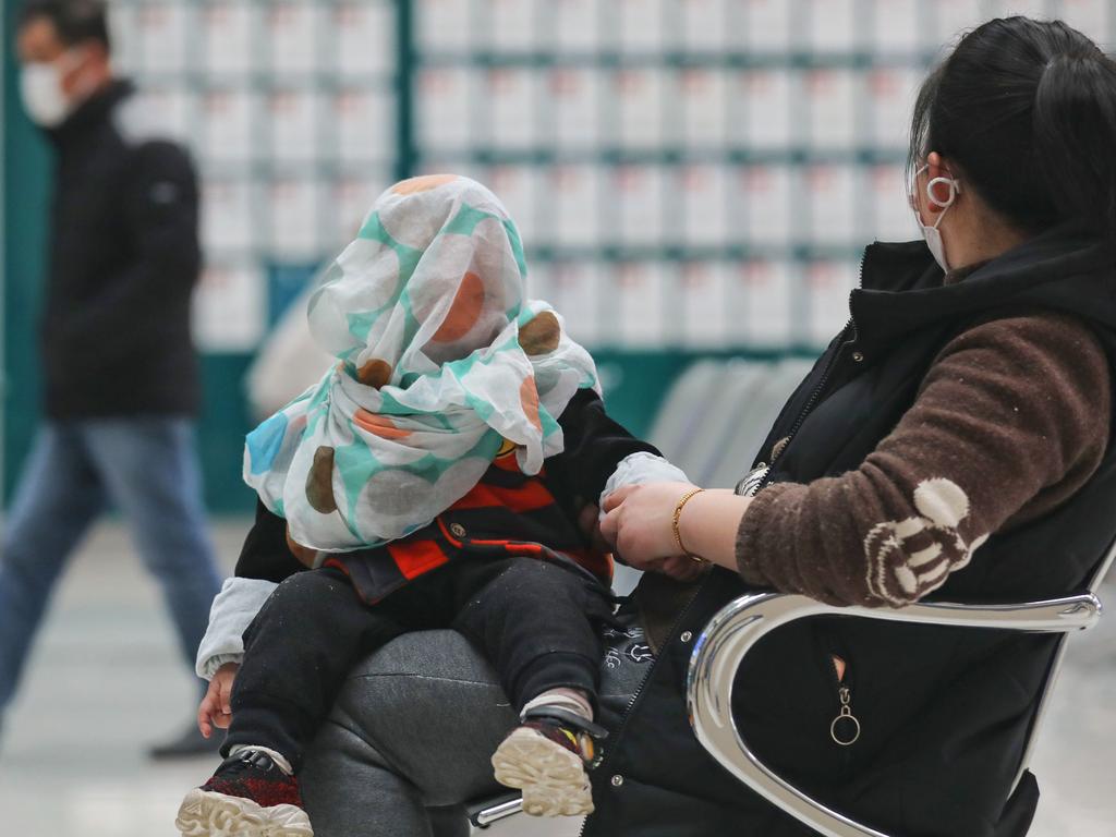 A woman visits a hospital with a child in Wuhan, where the outbreak has been deemed to have passed. Picture: STR / AFP.