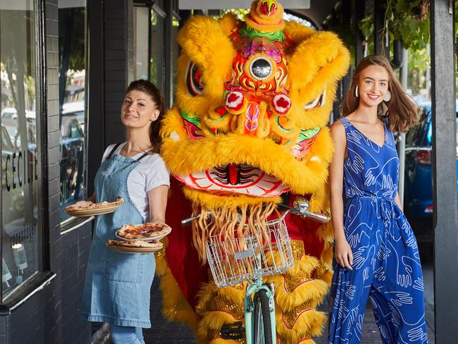 Marika Ameglio, Ryan Cusack the Chinese Lion pose for a picture with Felicity Jackson, 17 wearing Elk down King William Road in Hyde Park, ahead of the Unley Gourmet Gala evening festival of local food, fashion and dance, Wednesday, Jan. 9, 2019. Picture: MATT LOXTON