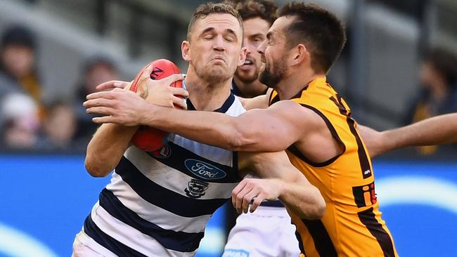 Joel Selwood is tackled by Luke Hodge.