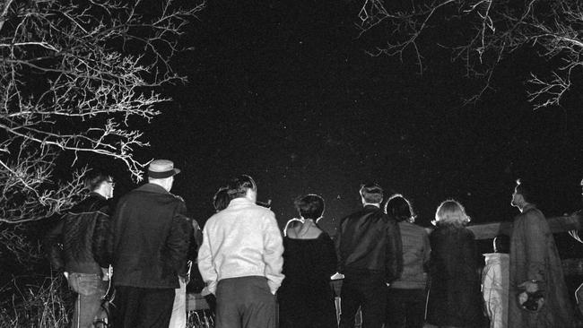 Curious citizens turn out by the hundreds to scan the night sky for unidentified objects near the scene of a reported sighting in Michigan in 1966. Picture: Getty Images