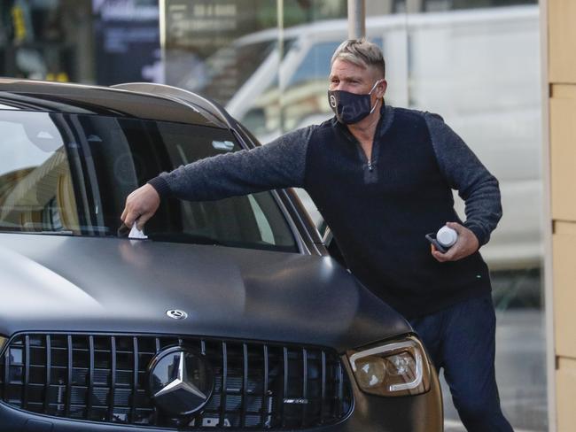 Shane Warne, wearing a personalised SW mask, cops a parking ticket in Melbourne this week. Picture: Media Mode