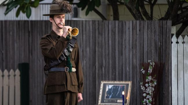 Lighting up the dawn Anzac Day Berrima Street Wynnum The bugler is Derek Miller (whoÕs been playing for nine years), wearing a Light Horse outfit.] photo Neale Maynard