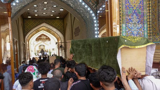 Iraqis transport coffins of relatives killed during a fire in a Baghdad hospital. Picture; AFP.