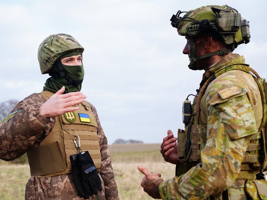 A member of the Australian Armed Forces talks with a Ukrainian soldier. Picture: AFP