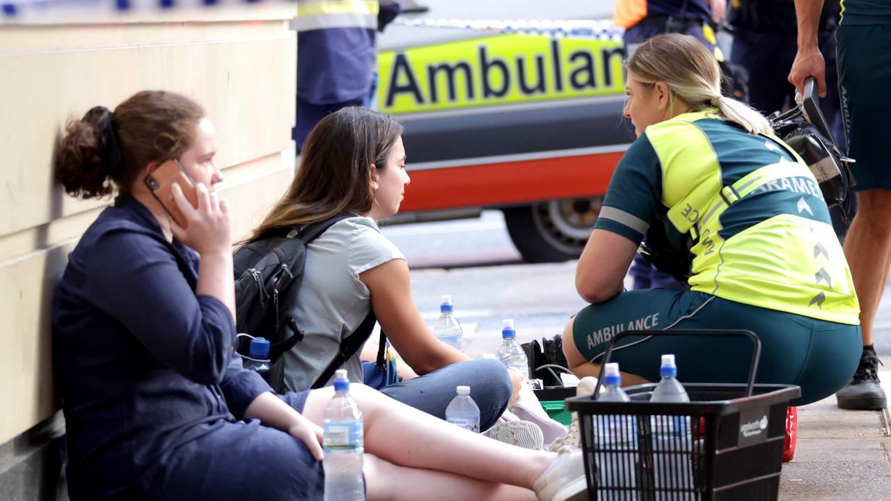 A paramedic speaks to witnesses at the scene of Friday night’s crash. Picture: Steve Pohlner