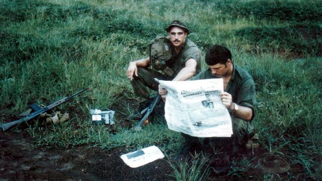 Ted Stanton photo of "Dutchy" and "Moose" reading the Centralian Advocate At Wallaby Pad waiting for an airlift to "Horseshoe" in Vietnam. Picture: SUPPLIED