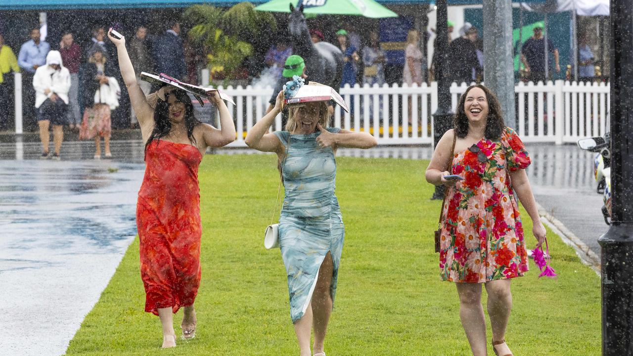 People leaving a wet Magic Millions Raceday at Gold Coast Turf Club. Picture: Richard Walker