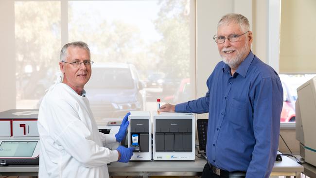 Alice Springs Hospital Pathology Department microbiology supervising scientist James McLeod and laboratory manager David Hallett with the unit used to process coronavirus tests. Picture: EMMA MURRAY