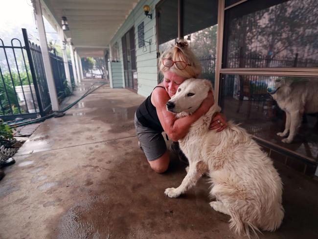 Freda Louizos hugs her dog JoJo in Killabakh, near Taree in November. She is one of dozens of pet owners who refused to abandon their pets. Picture Gary Ramage