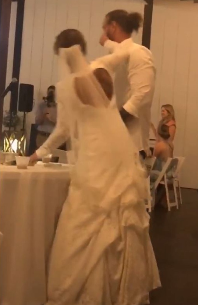 The bride can be seen smothering a piece of cake into the face of her partner. Picture: TikTok/kelsboyd3